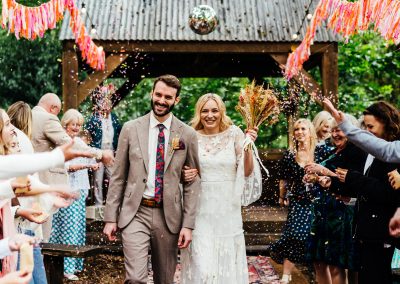 A couple leave their vintage themed woodland wedding at Hothorpe Venues