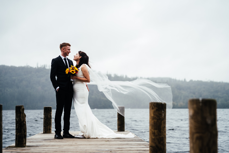 newly weds having their wedding photographs taken on the jetty after their Merewood just us elopement